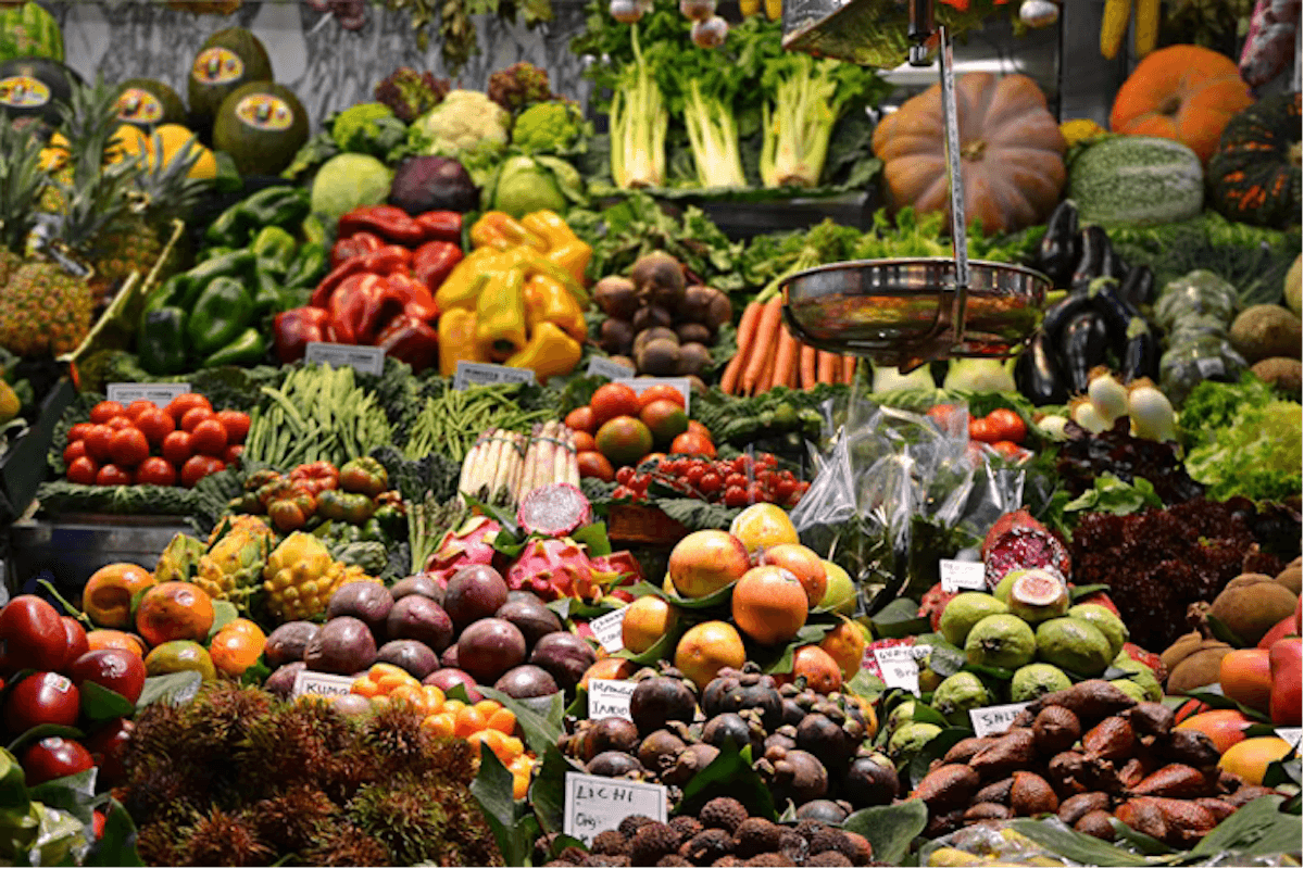 A vibrant display of fresh fruits and vegetables at a market stall, showcasing a wide variety of colors, textures, and produce. These represent the theory of Dr Georgia Ede that one should ‘eat whole foods. Nothing else’ in Change Your Diet, Change Your Mind, of the book’s we’d recommend to readers asking ‘what should I read next?’